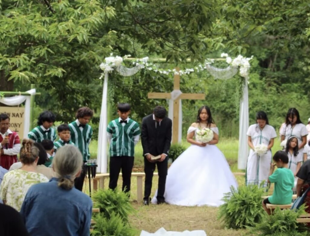 Wedding ceremony with a cross in the background